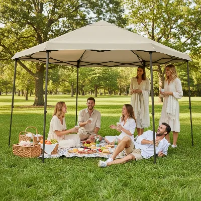 Friends enjoying a picnic under a portable gazebo tent in a lush green park